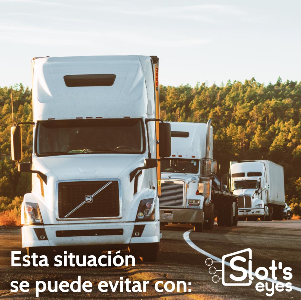 Fila de camiones circulando uno detrás de otro por una carretera al atardecer